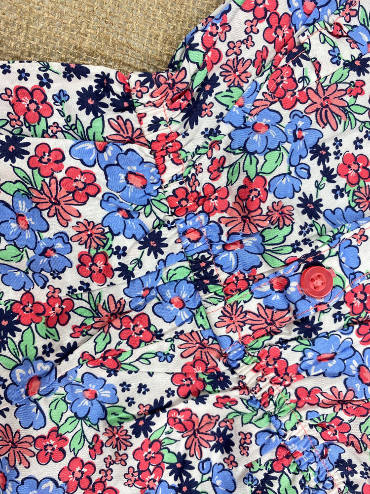 رامپر نوزادی دخترانه آستین تاپ طرح گل گلی آستین چین داره حلقه ای جلو دکمه ای سفید رنگ - 12 ماه