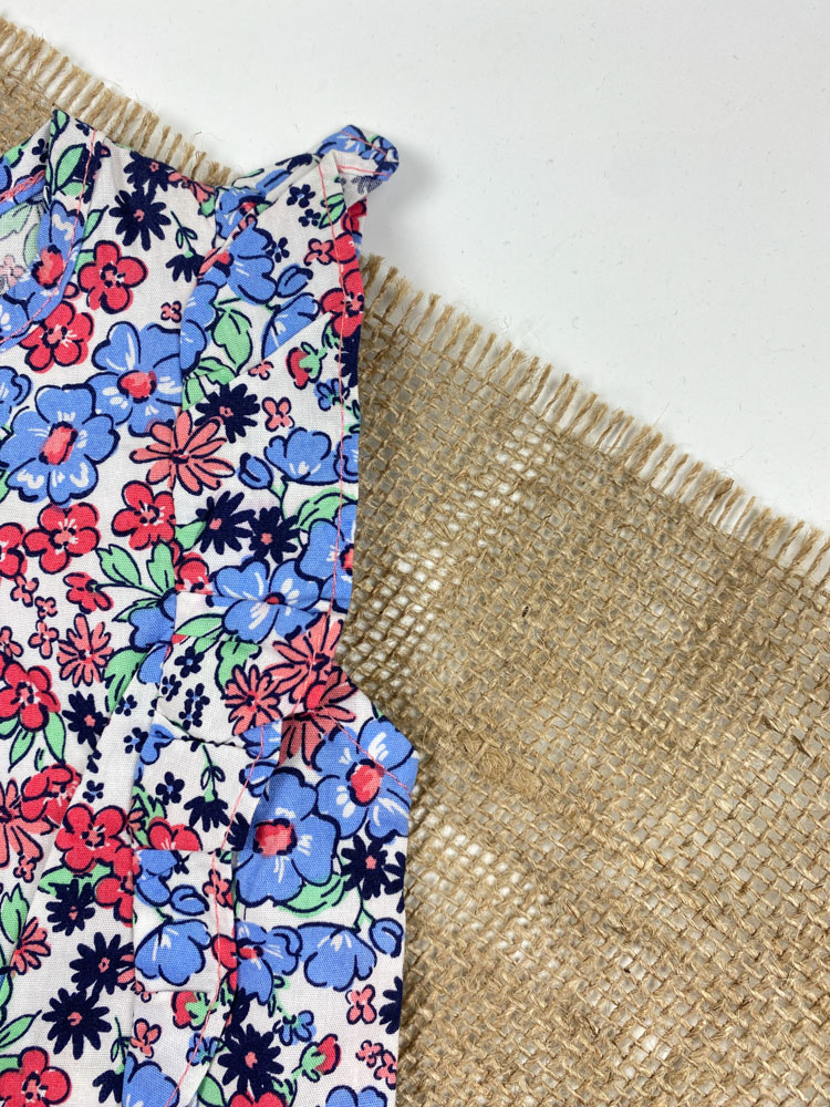 رامپر نوزادی دخترانه آستین تاپ طرح گل گلی آستین چین داره حلقه ای جلو دکمه ای سفید رنگ - 12 ماه