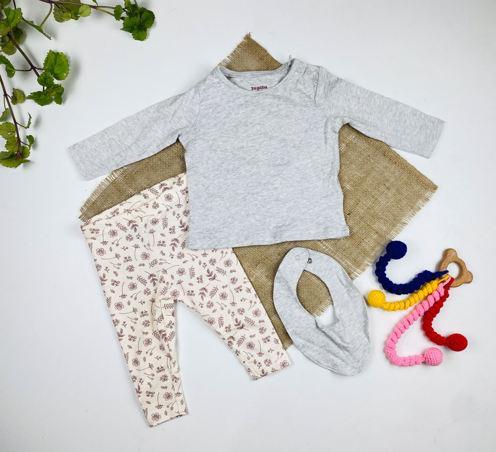 ست سه عددی نوزادی دخترانه آستین بلند برند لوپیلو طرح بلوز ساده شلوار گل گلی یقه گرد و پیشبند دار طوسی رنگ